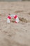 Close-up Of Miniature Lifebuoy Dig In The Sand At Beach