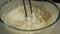 Close-up of mixing ingredients in a glass bowl with an electric mixer. Slow motion. The concept of a bakery. Preparation