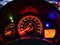Close up modern car`s dashboard with speedometer fuel indicator temperature light and tachometer at night.
