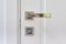 Close up of modern chromed metal door handle on a white interior door