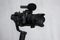 Close up of modern dslr camera on 3-axis gimbal stabilizer with microphone over gray background