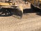 Close-up of moldboard planning road surface. Blade of motor grader during road construction works