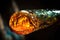 close-up of molten glass on blowpipe