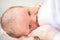 Close up. mom feeds newborn standing in a white interior. breast-feeding.