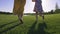 Close-up mom and girl running barefoot on grass