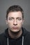 Close up moody vertical portrait of young casual man wearing sports hoodie