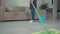Close-up of mopping floor in living room. There is a bucket with water nearby.