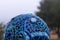 Close-up of mosaic garden ball in shades of blue made from stained glass tiles, abstract design