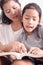 Close up mother and daughter reading a book together