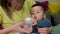 Close up of mother holding a baby boy, giving him a water from bottle