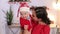 Close-up of a mother holding a small child wearing a Santa hat. Christmas.