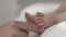 Close up of mother's hand touching bare feet of newborn baby