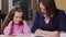 Close-up mother teaching little daughter, reading color book