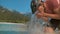 CLOSE UP Mountain biker stops during his ride to wash his face with glassy water