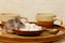 Close-up mouse climbs on a plate of sugar near the coffee cups on kitchen table.