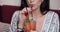 Close-up mouth of fashion female model drinking fresh cocktail using straw holding glass by hands