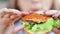 Close-up mouth of hungry beautiful girl eating tasty fresh burger enjoying fast food