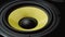 Close up at moving sub-woofer. Speaker part. Black and yellow colors. Slo-mo