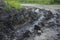 Close-up of a muddy ditch from a car wheel