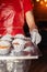 Close-up of muffins on a tray. Powdered sugar cakes. The work of the confectionery industry. Each cupcake is wrapped in paper