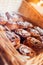 Close-up of muffins on a tray. Powdered sugar cakes. The work of the confectionery industry. Each cupcake is wrapped in paper