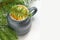 Close-up mug of lobule orange mandarin or tangerine on green natural fir tree branches background.. Creative Christmas