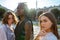 Close up multi ethnic portrait of two european brunette girls and one afroamerican girl with sunglasses standing among