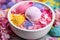 close up of multicolored bath bomb ingredients mixed in a marble bowl