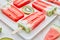 Close-up of a multicolored fruit frozen smoothies with round pieces of kiwi and triangular pieces of watermelon in a