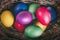 Close-up of multicolored traditional easter eggs painted in blue, pink, purple, yellow colors in basket. Vintage tone.
