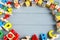 Close up Multicolored wooden cubes with letters, pencils, rainbow arc on gray background. Set of toys for studying alphabet.