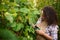 Close-up multiethnic winegrower woman using garden shears picking ripe and juicy organic grapes in an eco vineyard.