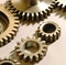 Close up of multiple brown cogs and gears on white background