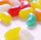 Close up of multiple colourful sweet jelly beans on white background