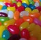 Close up of multiple colourful sweet jelly beans on white background