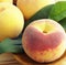 Close up of multiple peaches on plate on wooden background