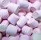 Close up of multiple pink marshmallows lying on black background