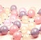 Close up of multiple purple and pink balloons on beige background