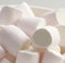 Close up of multiple white marshmallows lying on white background