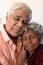 Close-up of multiracial senior couple with eyes closed embracing against wall in retirement home