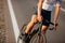 Close up of muscular cyclist standing on road with bike