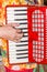 Close-up the musician fingers playing the red accordion, the street musician show.