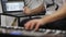 Close up of musician playing midi keyboard in home music studio.