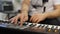 Close up of musician playing midi keyboard in home music studio.