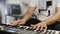 Close up of musician playing midi keyboard in home music studio.