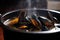 close-up of mussels in seafood soup, with steam rising from the broth