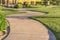 Close up of narrow paved pathway winding through lush grasses on a sunny day