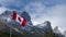Close up of National Flag of Canada with natural mountains and trees scenery