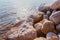 Close up of natural salt crystals, texture of salt. Small waves touching against salted rock shore at the Dead Sea coast.