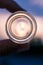 Close up of neck of essential oil glass bottle hanged with fingers